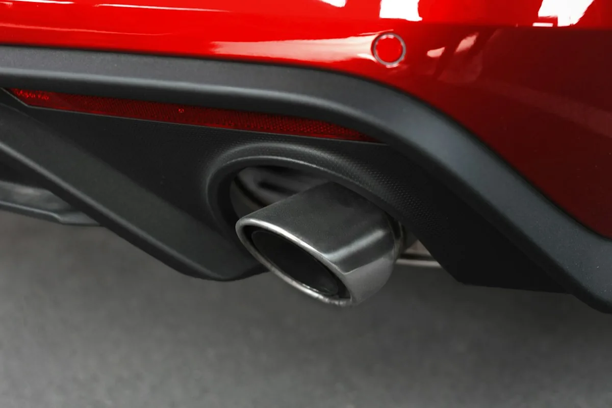 Escapamento esportivo na traseira de um carro vermelho